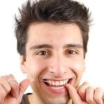 Man Using Dental Floss To Clean Teeth - Trade Winds Dental