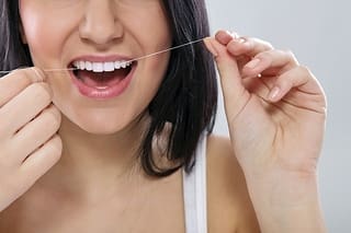 Woman Flossing Healthy Smile - Trade Winds Dental