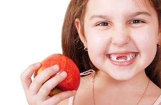 Pediatric Dental Patient Eating Apple - Trade Winds Dental