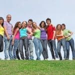Family Standing On Hill Smiling Together - Trade Winds Dental
