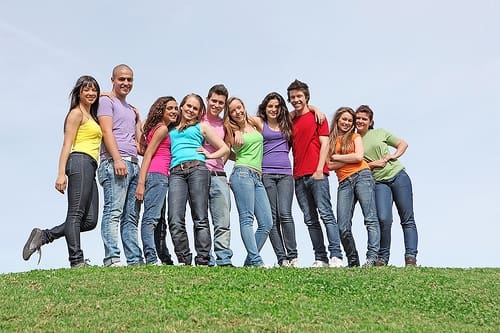 Family Standing On Hill Smiling Together - Trade Winds Dental