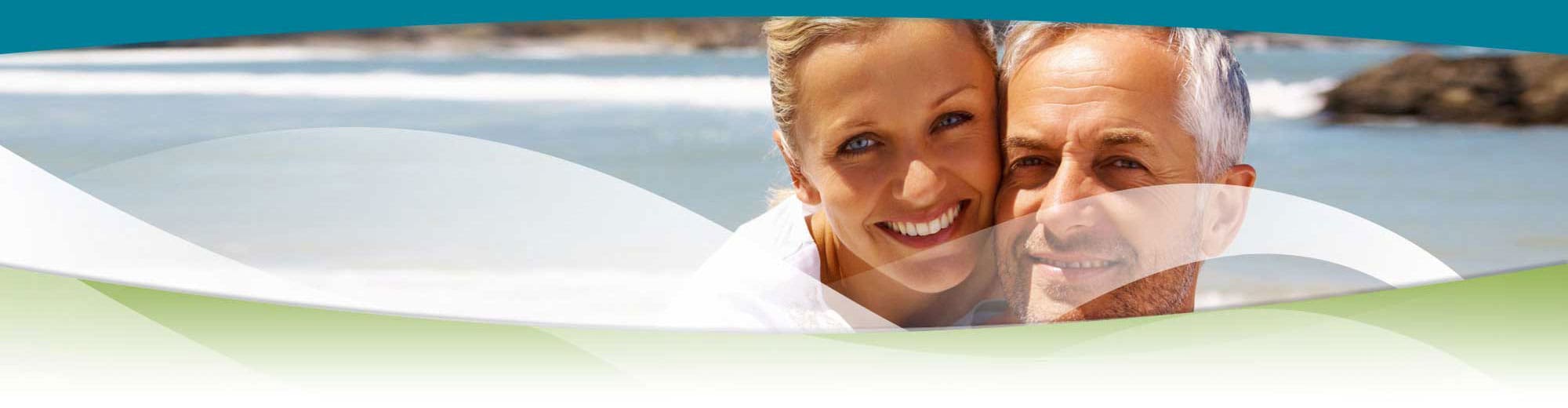 Middle Aged Couple Smiling At Beach - Trade Winds Dental