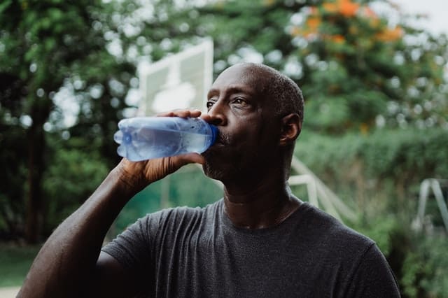 Man Drinking From Water Bottle - Trade Winds Dental