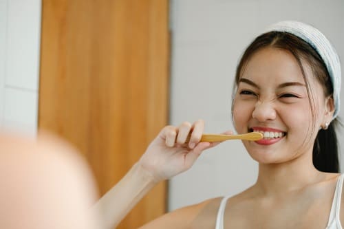 Woman Brushes Her Teeth - Trade Winds Dental
