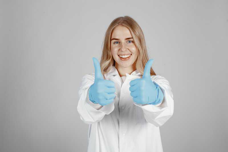 Girl In Lab Coat Giving Two Thumbs Up - Trade Winds Dental