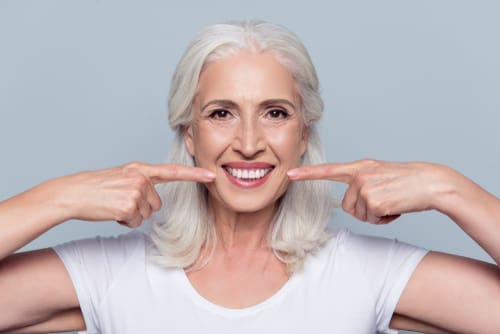 Woman smiling with all on 4 implants - Trade Winds Dental