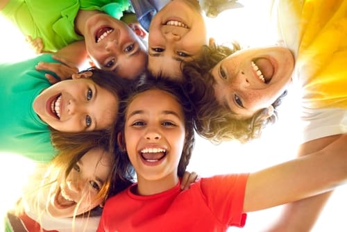 Group of kids smiling with fluoride treated teeth - Trade Winds Dental