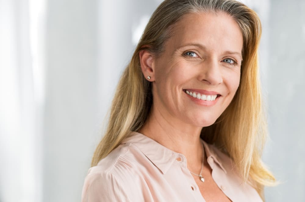 Woman Smiling with Denture Implants - Trade Winds Dental